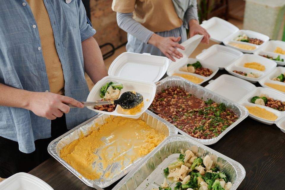 Personas preparando alimentos para una entrega comunitaria. Fotografía ilustrativa.
